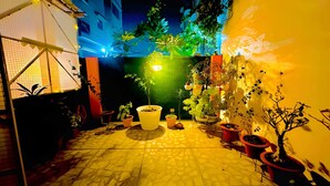 A courtyard with potted plants, a tiled floor, and a tent structure. - EASY INN Holiday Home | 3BHK Apartment (Lucknow)