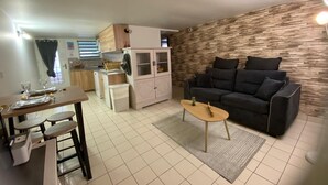 A compact living space with a kitchenette, a dining area, and a seating area with a sofa and coffee table. - One-bedroom apartment near Disney and Paris (Dampmart)