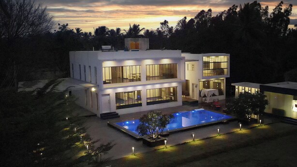 A modern two-story house with a swimming pool, large windows, and a small adjacent structure. - Magnolia - 3BR Private Pool Villa (Kanakapura)