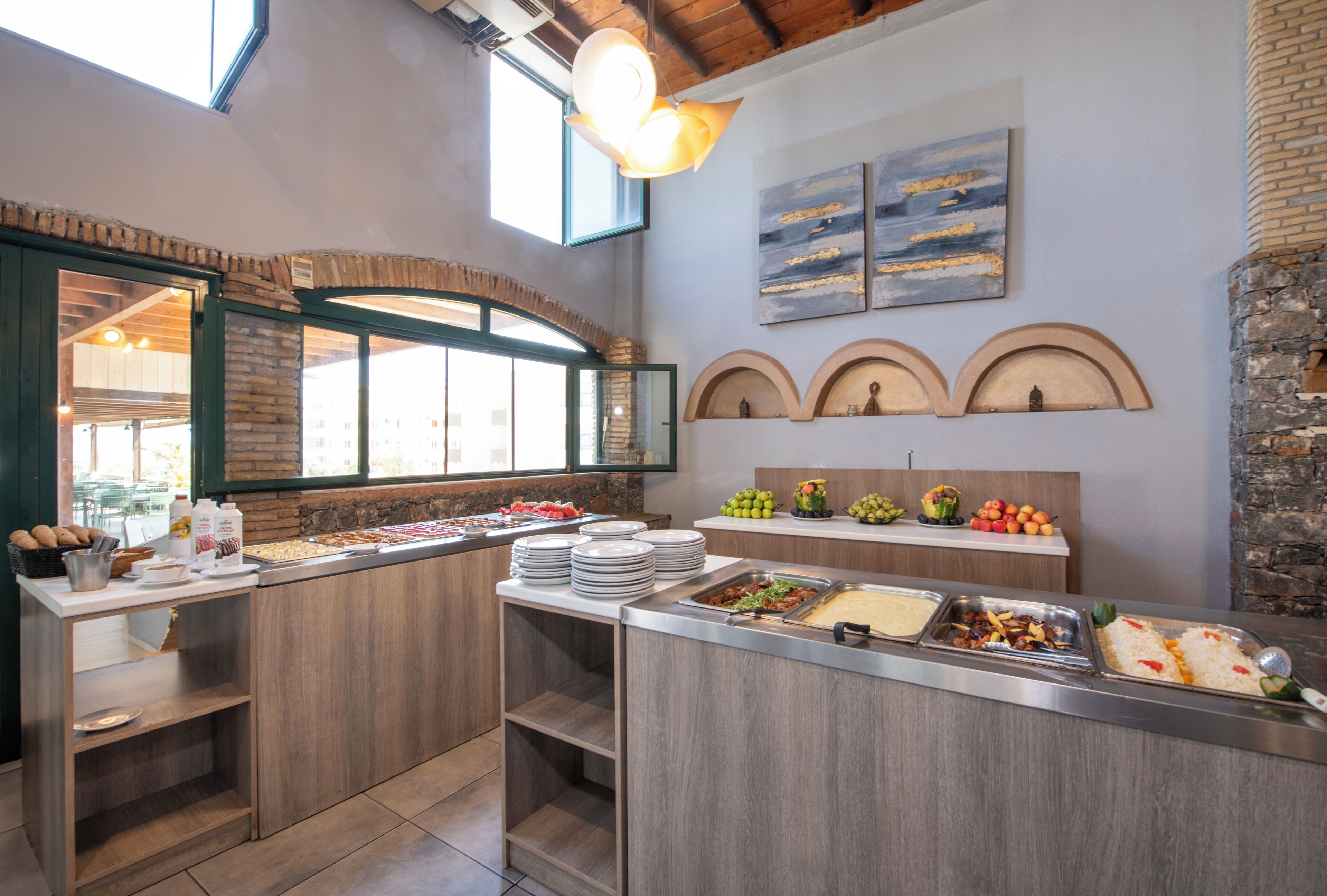 A buffet setup with various food items and a stone wall.