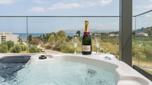 Ein Whirlpool mit einer Moët & Chandon Champagnerflasche und zwei Gläsern, mit Blick auf eine schöne Landschaft.