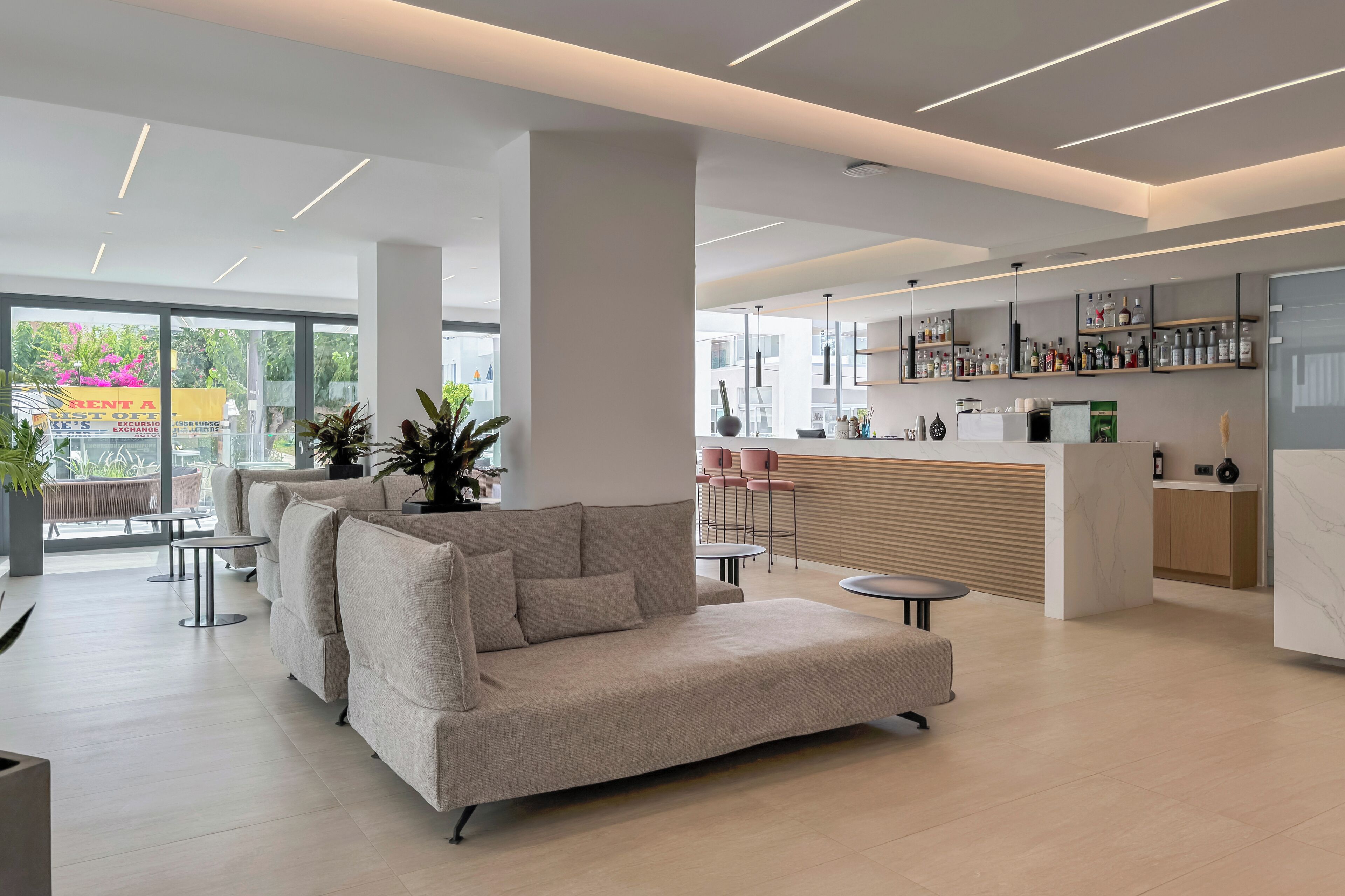En moderne lobby med sofa, borde og et barområde.