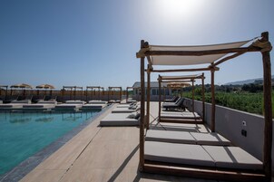 Una piscina al aire libre de temporada, sombrillas