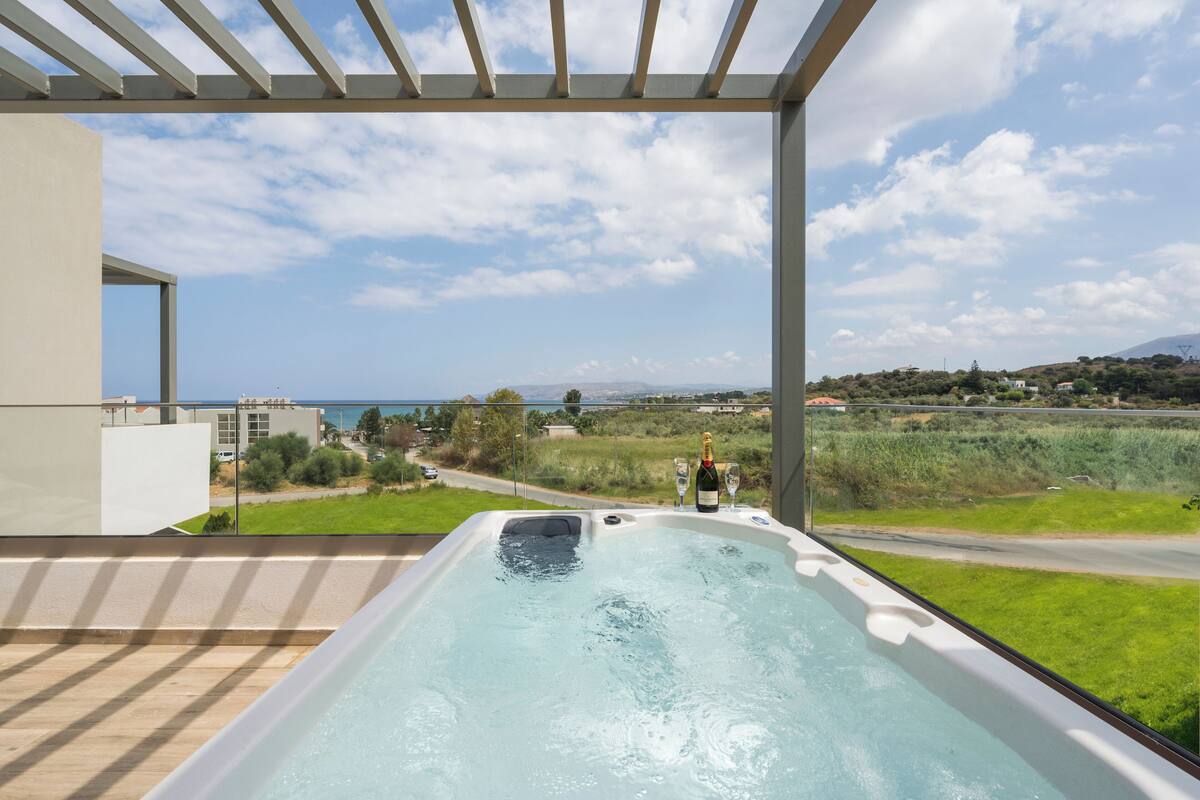 A hot tub with a view of the sea and countryside.