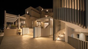Ein modernes Gebäude mit großzügigem Außenbereich, einer Treppe und einem gut beleuchteten Eingang.