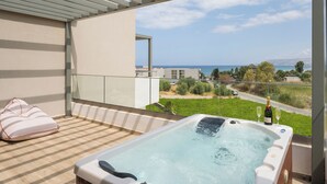 Ein Balkon mit Whirlpool, einer Champagnerflasche und einem Glas.