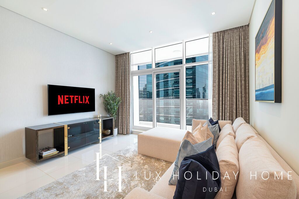 A modern living room with a large window, a Netflix TV, a sofa, and a console table.