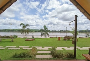 Un espace verdoyant avec vue sur un lac, des bancs et un sentier.
