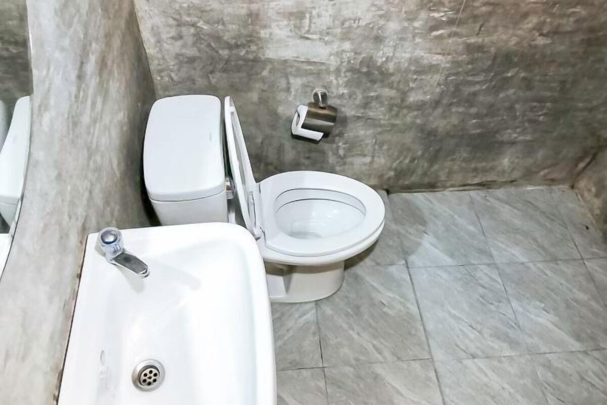 A bathroom with a white sink, toilet, and marble flooring.