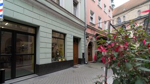 A narrow street with a building featuring large windows and a door.