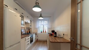 A modern kitchen with white cabinets, a wooden countertop, and a built-in oven.