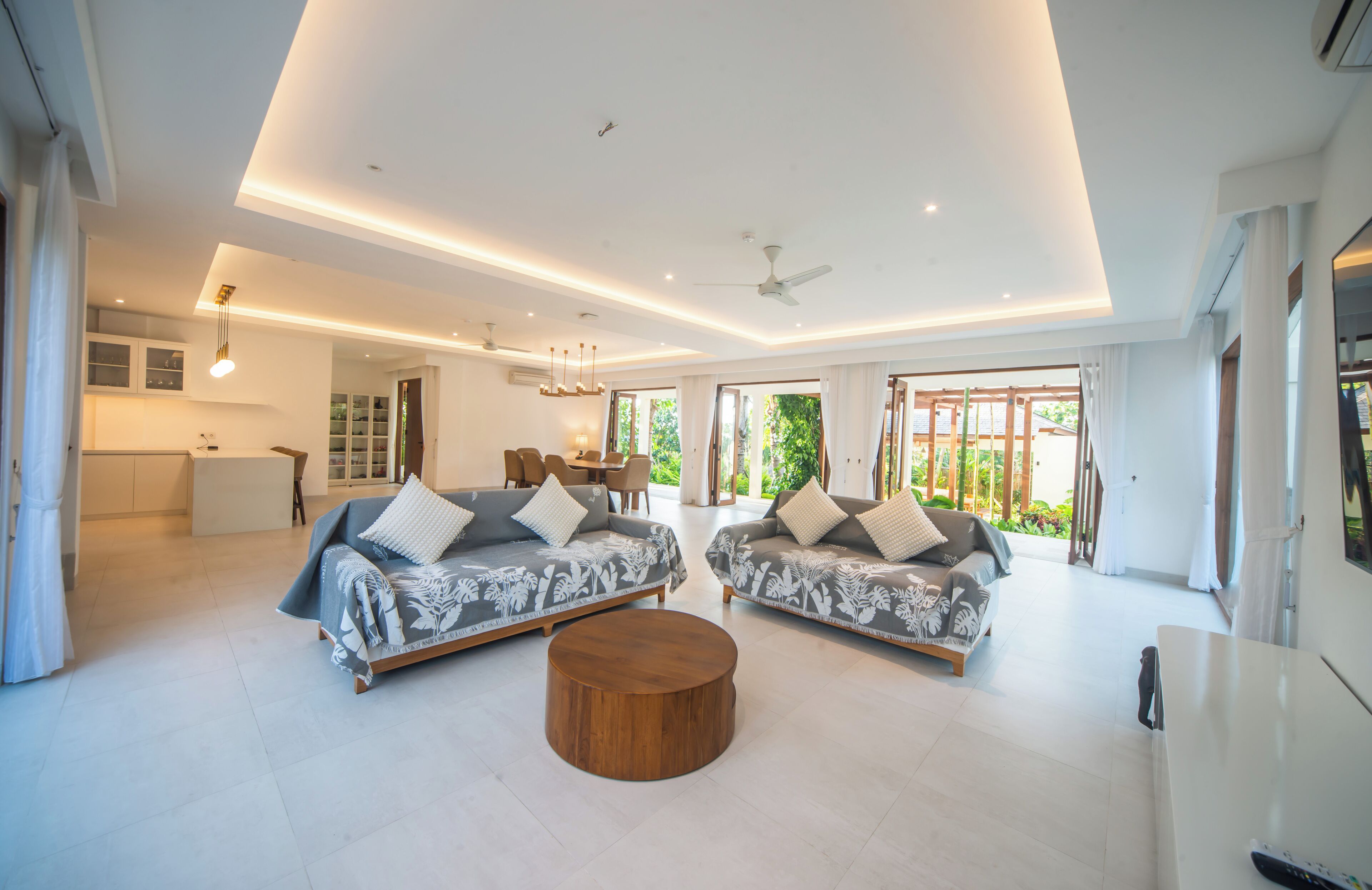 A spacious living room with two sofas, a coffee table, and a dining area.