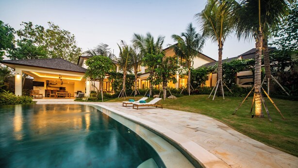 A swimming pool with lounge chairs, a covered patio, and palm trees. - Luxury 4 Bedroom Bella Vista Villa (Ungasan)