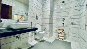 Ένα μπάνιο με λευκό νιπτήρα, τουαλέτα και χώρο για ντους.