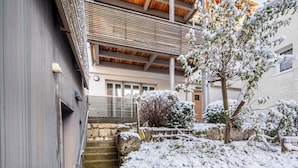 Un immeuble à plusieurs étages, avec un escalier menant à un espace extérieur abrité.
