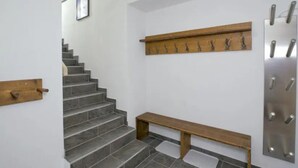 Un escalier avec une rampe en bois et un banc au bas.
