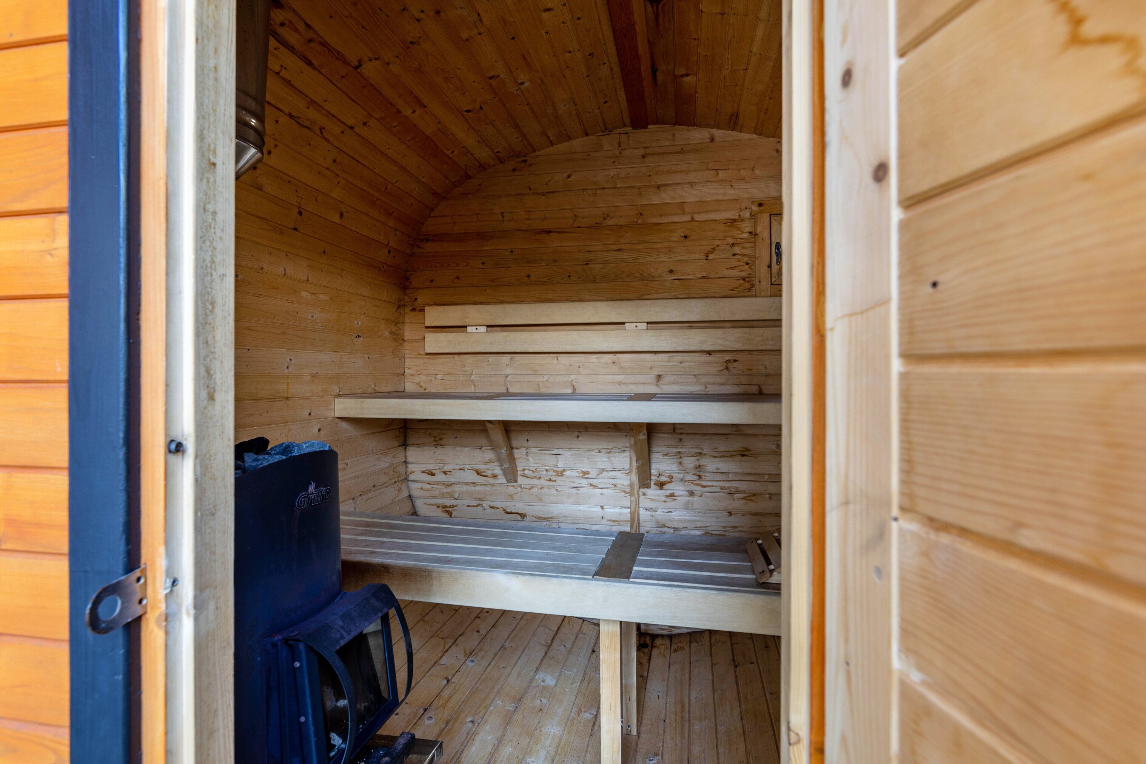 A wooden interior with a bench and a black object on the floor.