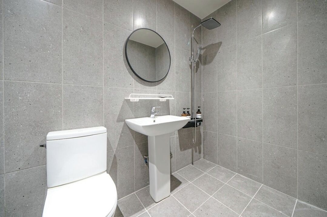 A modern bathroom with a toilet, sink, and shower.