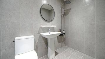 A modern bathroom with a toilet, sink, and shower.