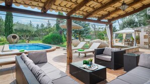 A covered outdoor area with a pool, lounge chairs, and a dining area. - Cas Mostatxet (sencelles) - Villa With Pool (Sencelles, Illes Balears)