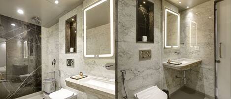 Un baño moderno con tocador de mármol, cabina de ducha de vidrio y inodoro separado.