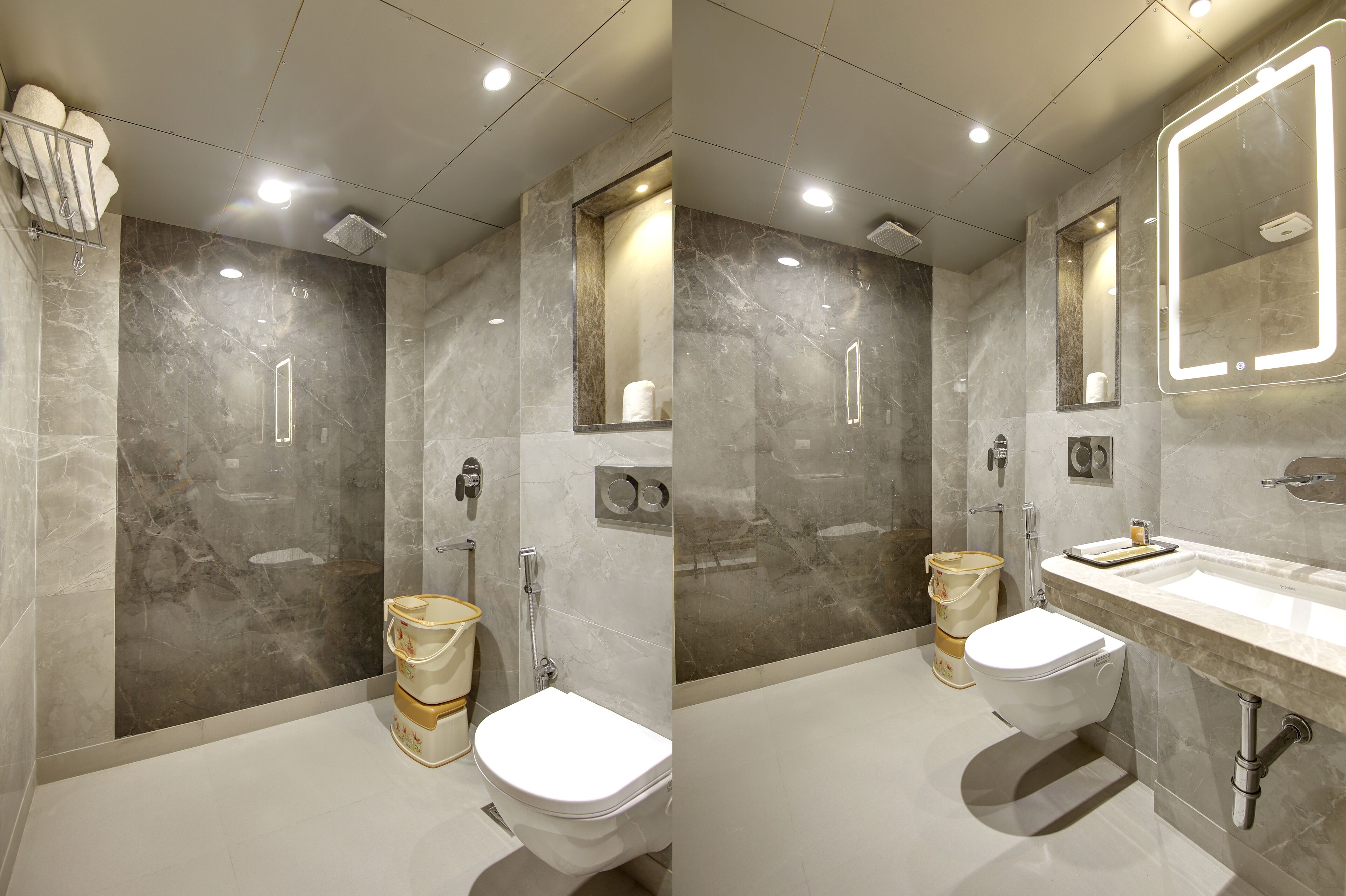 A modern bathroom with a marble wall, a large mirror, and a white sink.