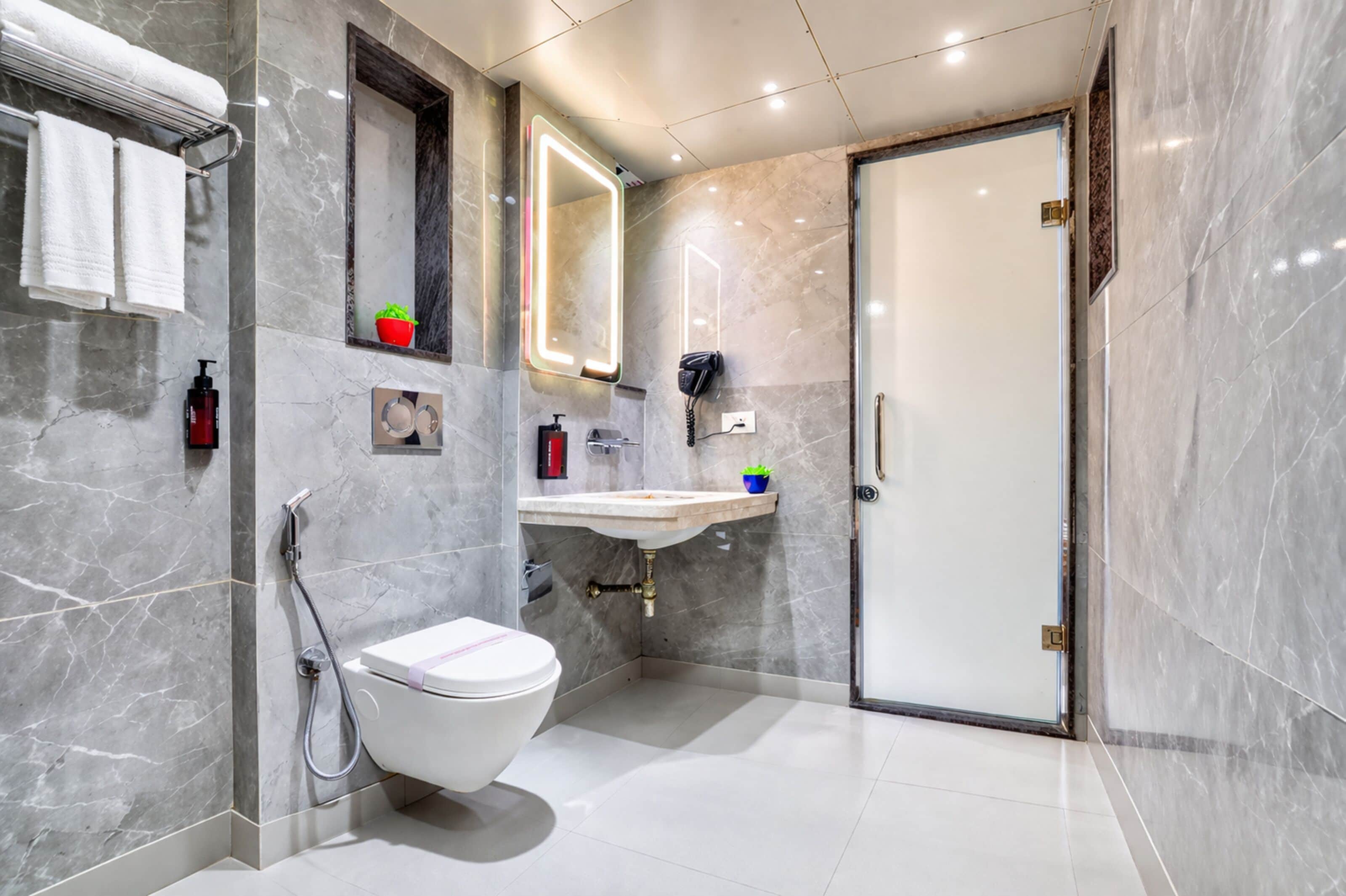 A modern bathroom with a toilet, sink, and shower.