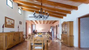 A dining area with a wooden table and chairs, a chandelier, and a wooden cabinet. - Pula ViÑas - Villa With Private Pool. Free Wifi (Son Servera, Illes Balears)