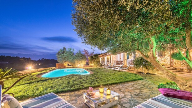 A pool area with lounge chairs and a dining table, surrounded by greenery and stone pathways. - Es Cocons - Villa With Private Pool In Sineu (Sineu, Illes Balears)
