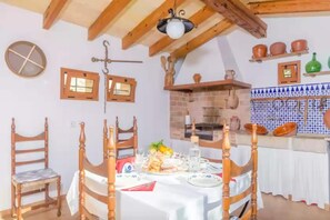Enjoy a warm meal in this cozy dining area with a traditional fireplace and wooden table.