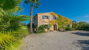 A stone building with a gravel driveway and palm trees. - Mercader - Villa With Private Pool In Alcúdia (Alcúdia, Illes Balears)