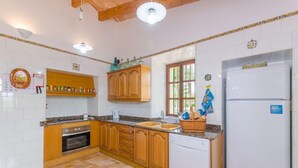 A kitchen with white tiled walls, wooden cabinets, a built-in oven, a sink, and a white refrigerator. - Son Real - Villa With Private Pool In Sencelles (Sencelles, Illes Balears)