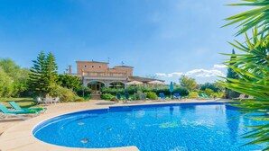 A swimming pool with lounge chairs and a building in the background.