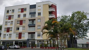 A multi-story building with a modern architectural design, featuring a mix of red, yellow, and beige colors.
