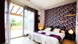 A bedroom with a bed, a large window, and a patterned wall.