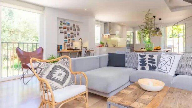 Ein modernes Wohnzimmer mit einer Couch, einem Couchtisch und einem Essbereich mit Tisch und Stühlen.