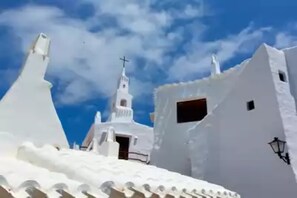 Stunning coastal building with a steeply pitched roof and a prominent cross at the top.