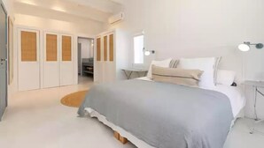 A modern bedroom with a large bed, a bedside table, a lamp, and a wardrobe. - Sa Blava - Villa With Private Pool. Free Wifi (, Illes Balears)