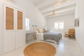 Cozy retreat with a high ceiling, exposed beams, and a comfortable bed.