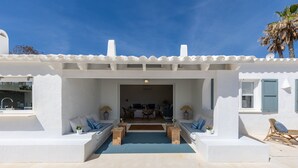 A modern white building with a covered outdoor seating area, a visible kitchen, and a clear view into the interior. - Sa Blava - Villa With Private Pool. Free Wifi (, Illes Balears)