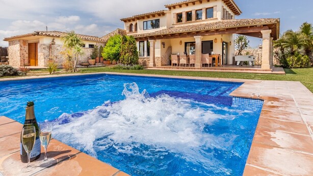 A large house with a swimming pool, a patio, and a covered outdoor seating area.