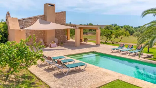 Un espace piscine avec des chaises longues et une pergola.