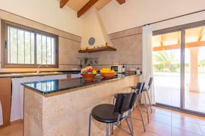 Enjoy cooking in this well-equipped kitchen with a central island, sink, stove, and ample counter space.