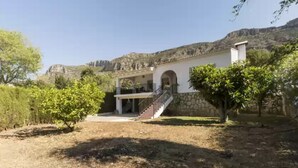 A house with a stone facade, a covered porch, and a staircase leading to the entrance. - Cova De L'aire - Villa With Private Pool In Barx (, Valencia)