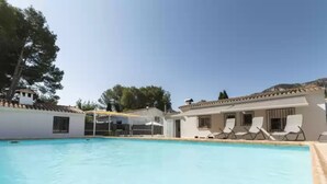 A swimming pool with lounge chairs, a covered area, and buildings with tiled roofs. - Cova De L'aire - Villa With Private Pool In Barx (, Valencia)