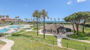 A resort with a swimming pool, palm trees, and a view of the ocean. - Las Americas - Apartment In Isla Cristina (, Huelva)