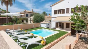 A residential property with a swimming pool, white lounge chairs, and a well-maintained lawn. - Ca Ne Margalide - Villa With Private Pool (, Illes Balears)