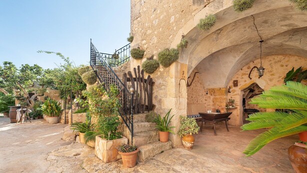 A stone building with a staircase, potted plants, and outdoor furniture. - San Sole - Villa With Private Pool In Felanitx (, Illes Balears)