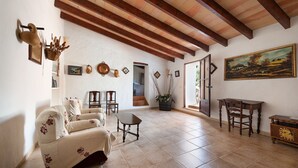 A spacious living room with a high wooden ceiling, a beige sofa, a wooden table, and a painting on the wall. - San Sole - Villa With Private Pool In Felanitx (, Illes Balears)