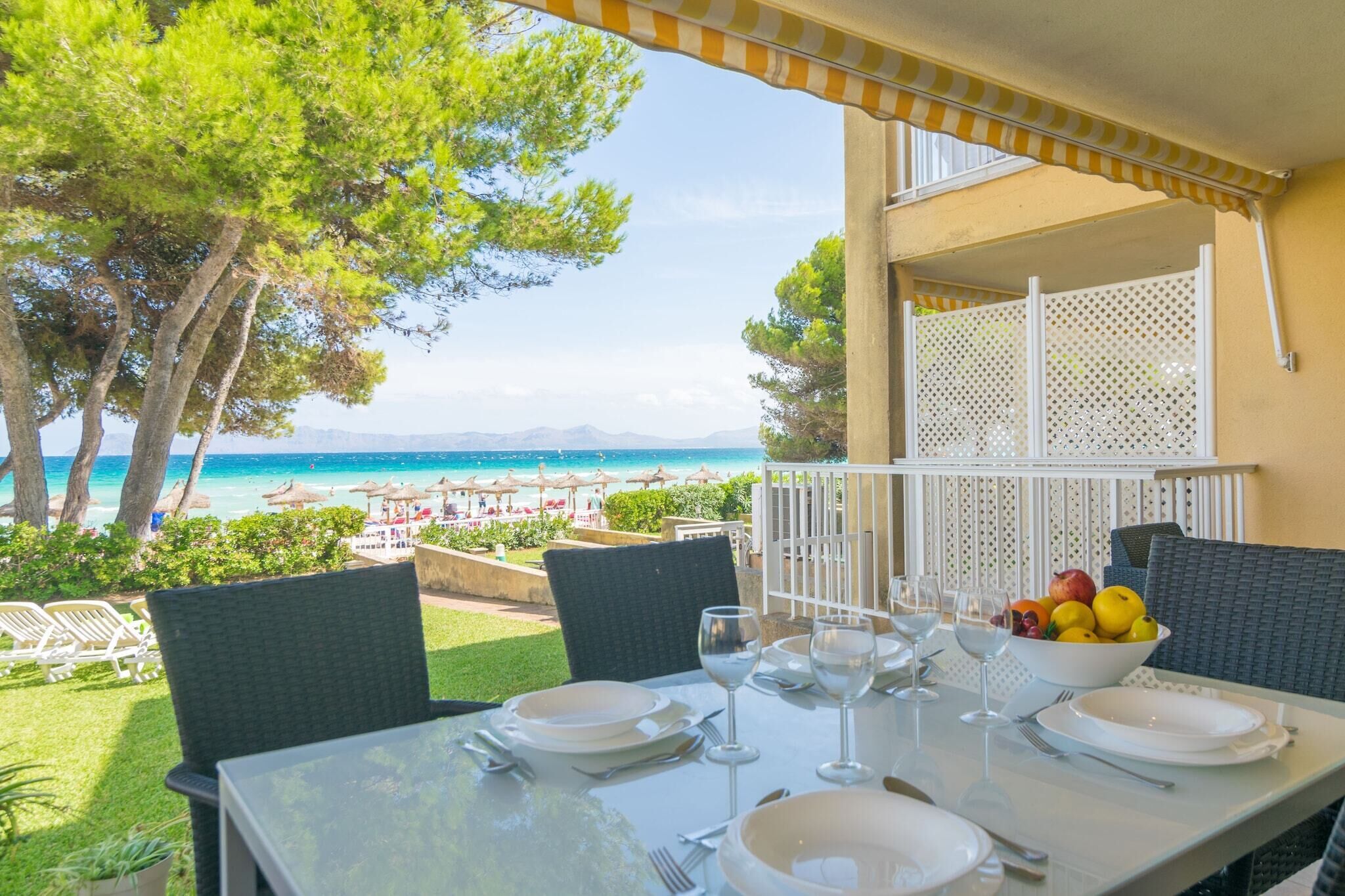 A table set for dining with a view of the beach and mountains.